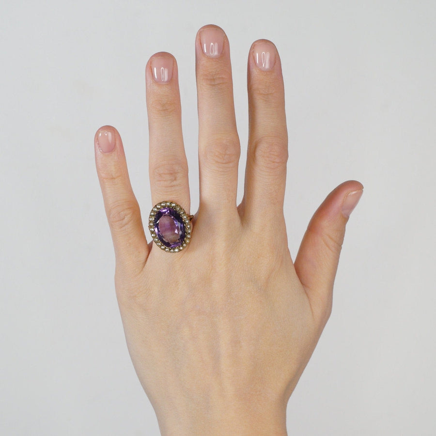 Large Edwardian 15ct gold cocktail ring featuring a stunning amethyst and seed pearls, worn on a hand.