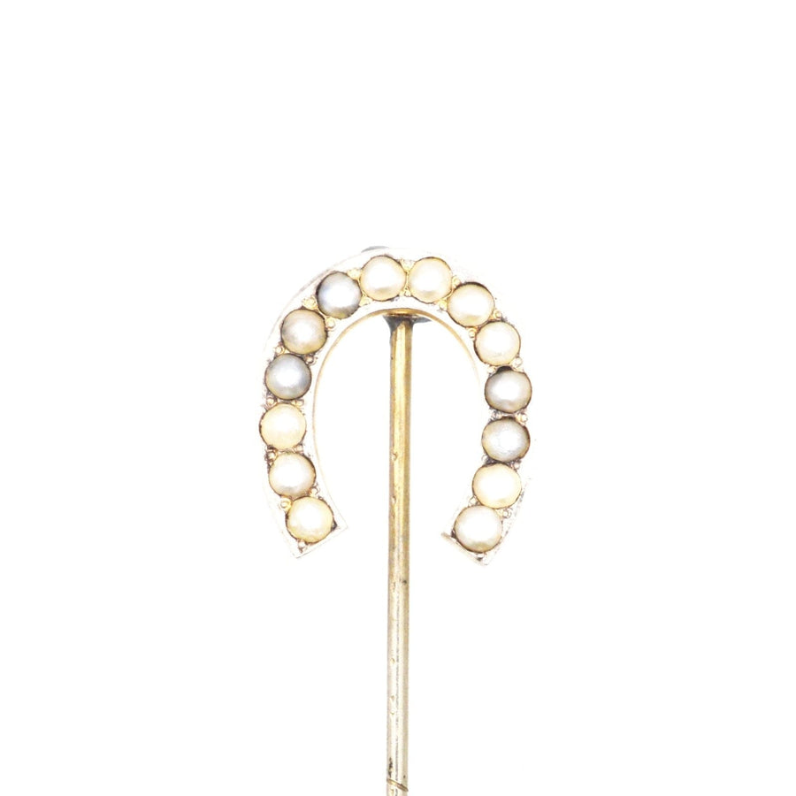 Large Victorian silver horseshoe brooch adorned with seed pearls, symbolizing good luck and protection.