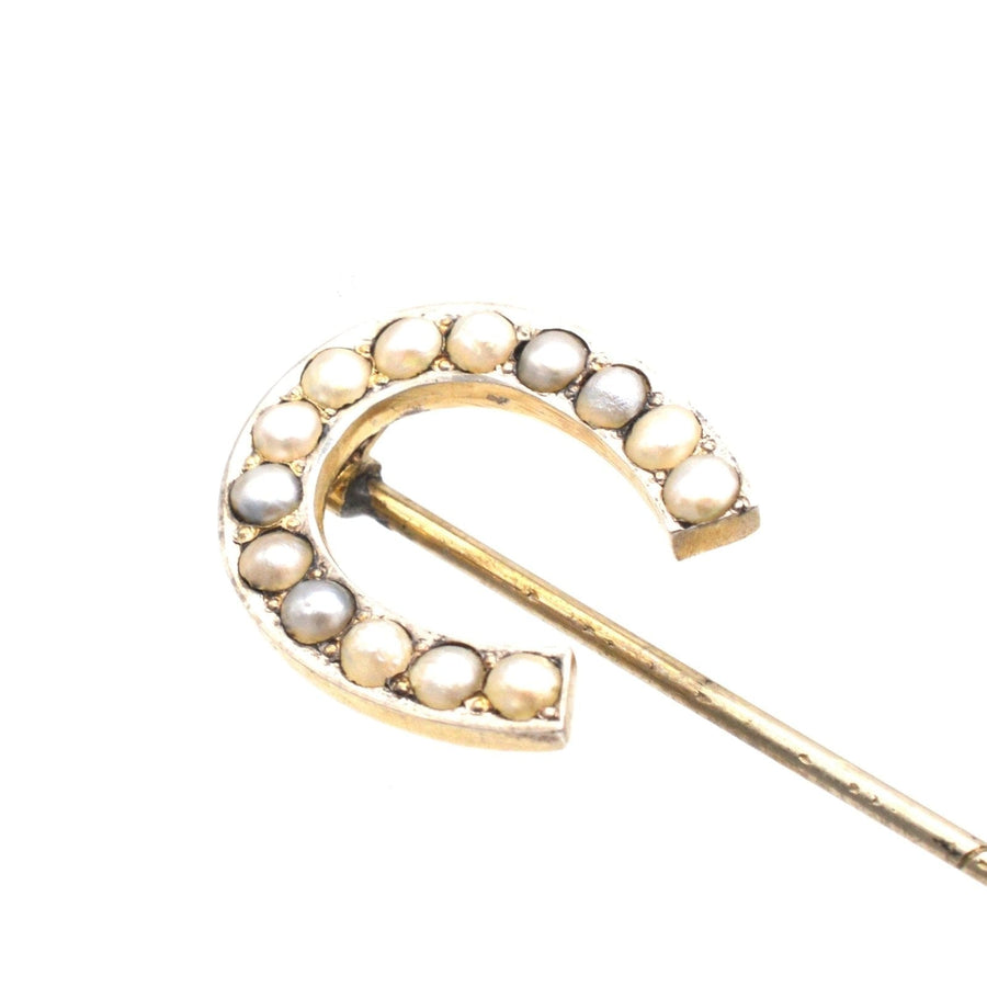 Large Victorian silver horseshoe brooch adorned with seed pearls, symbolizing luck and protection.