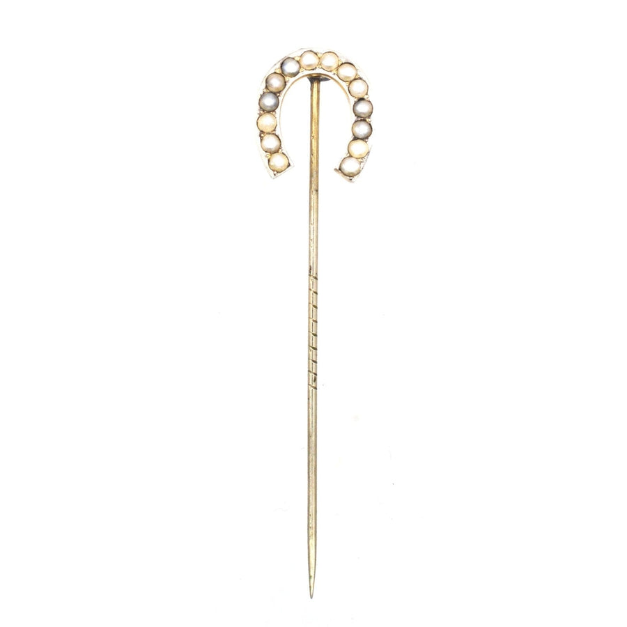 Large Victorian silver horseshoe pin adorned with seed pearls, symbolizing luck and protection.