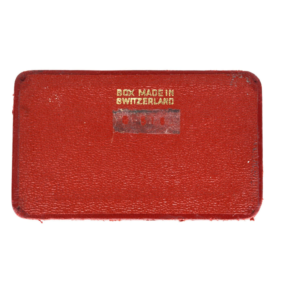 Red box with a gold embossed label reading 'Box Made in Switzerland', vintage collectible item.