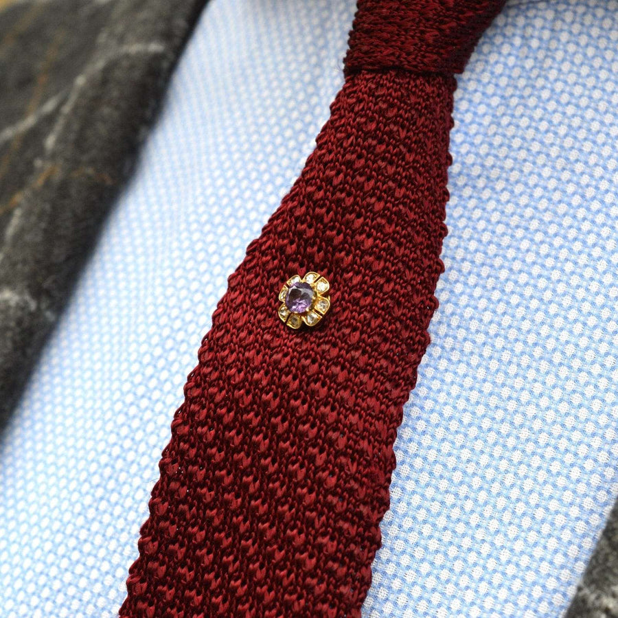 Late Victorian 15ct gold amethyst and diamond cluster tie pin on a red knitted tie.