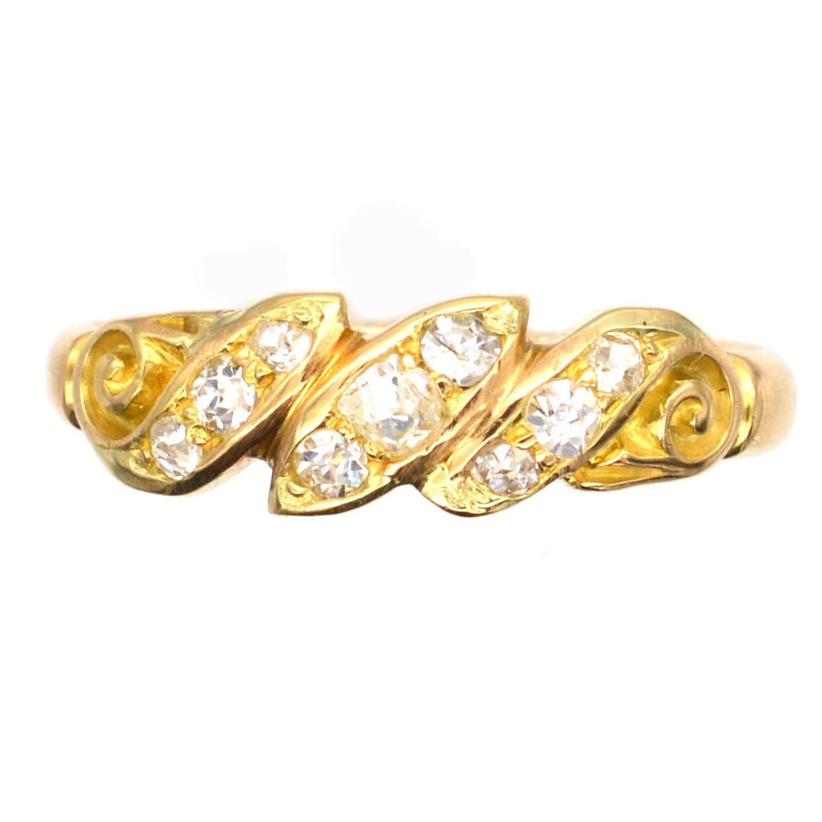 Late Victorian 18ct gold ring with old mine cut diamonds in a twist and scroll design, circa 1890.