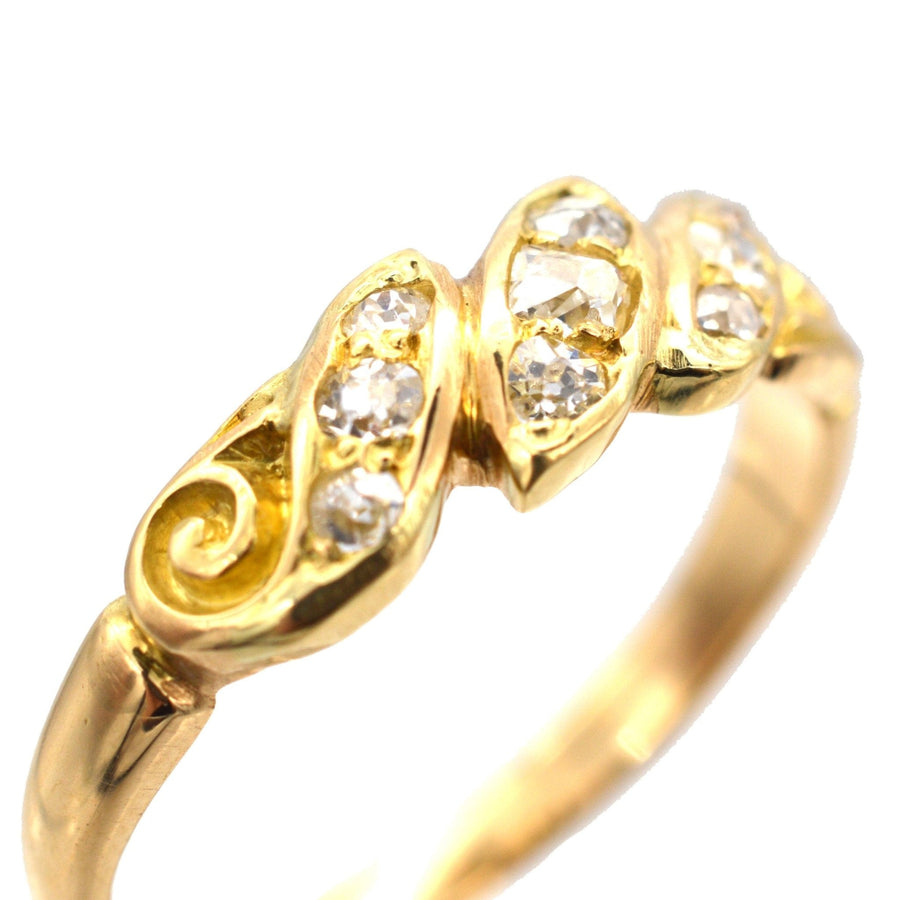Late Victorian 18ct gold ring with old mine cut diamonds in rope twist and scroll design.