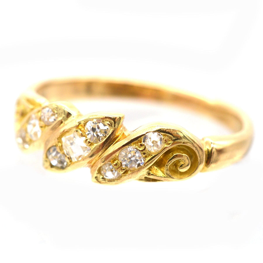 Late Victorian 18ct gold ring featuring old mine cut diamonds in a unique twist and scroll design.