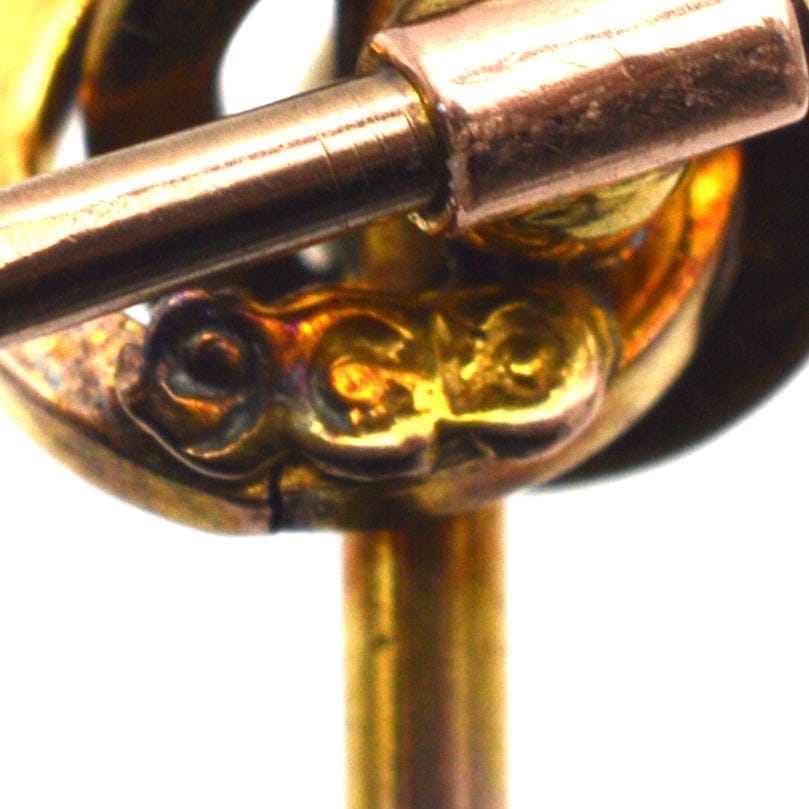 Close-up of 9ct gold hallmark on a Victorian knot tie pin with intricate design.