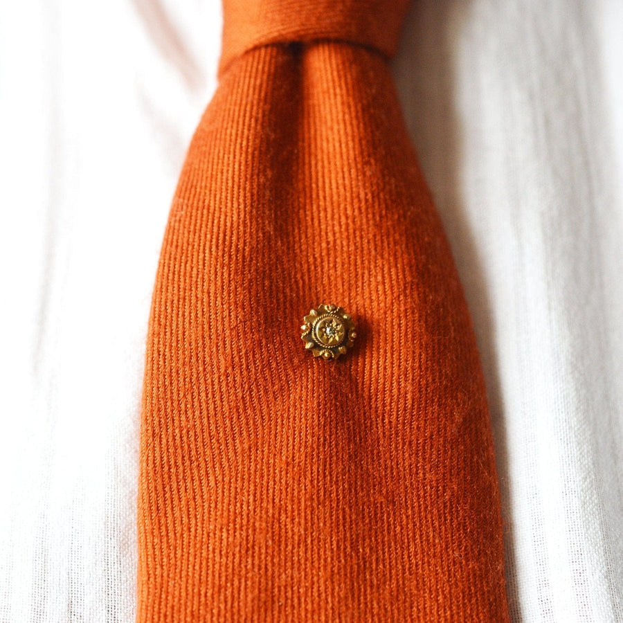 Late Victorian 9ct gold tie pin with diamond on an orange tie, circa 1880s, featuring a star motif and rope detail.
