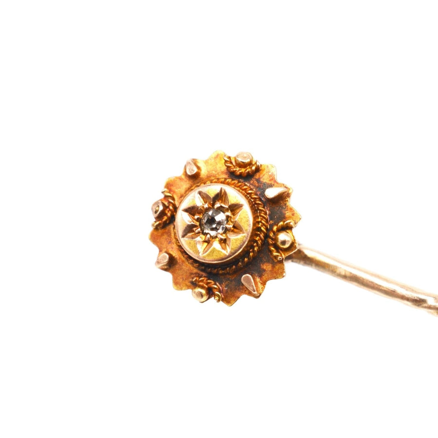 Late Victorian 9ct gold tie pin featuring a star motif and old cut diamond, circa 1880s, with intricate rope and ball detail.