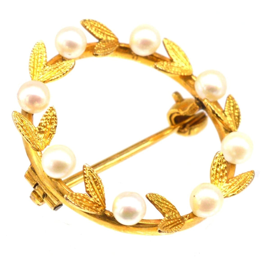 Mid 20th Century gold and cultured pearl laurel wreath brooch, symbolizing triumph and elegance.