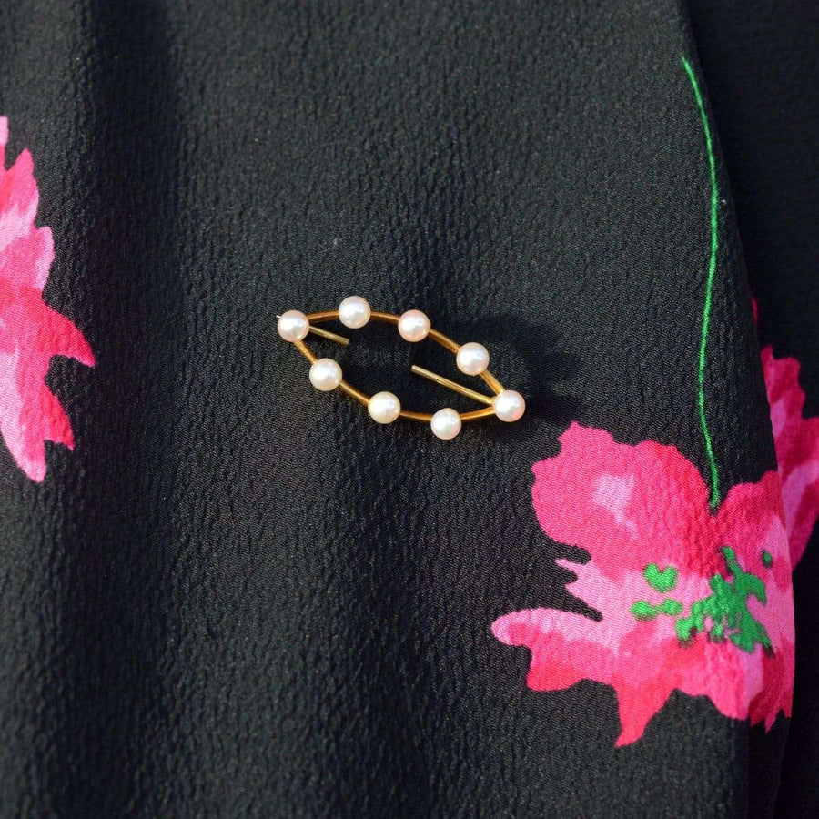 Mid Century 9ct gold marquise bar brooch with eight cultured pearls on a floral black dress.
