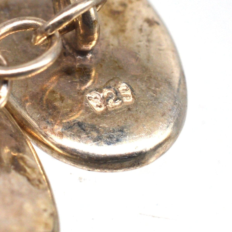 Close-up of vintage silver cufflinks showing craftsmanship and hallmarks.