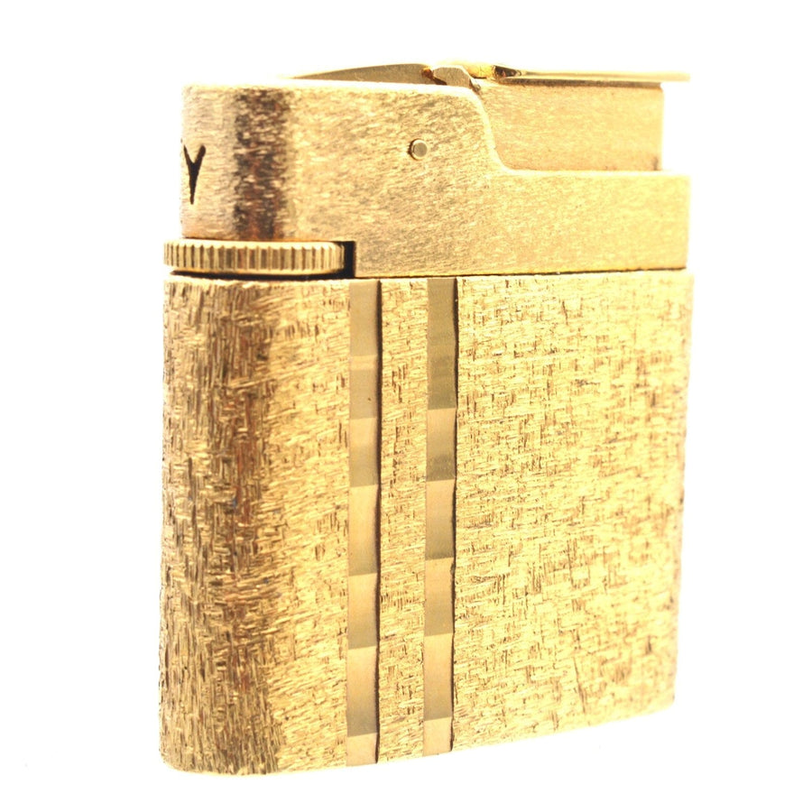 Vintage Norman Hartnell gold lighter with textured finish, part of a mid-century jewellery set.