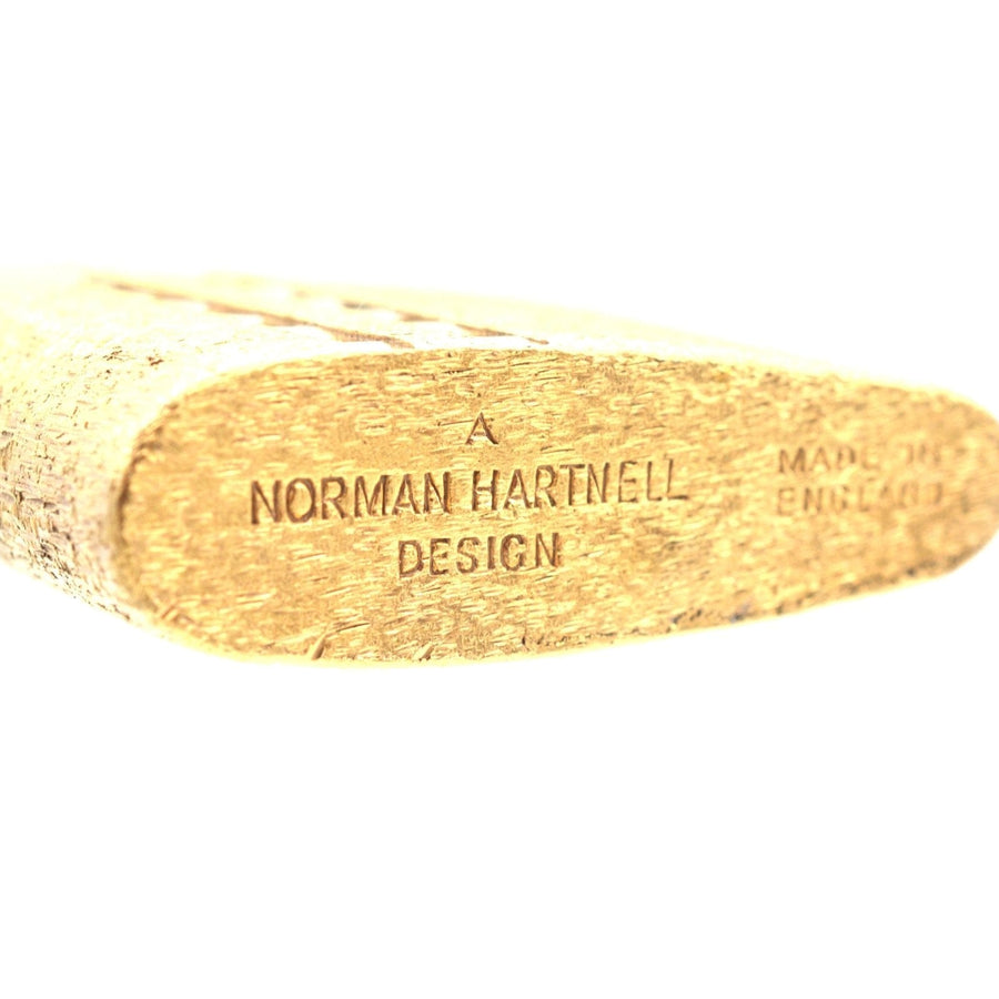 Close-up of a vintage Norman Hartnell design engraving on a lighter, showcasing craftsmanship and authenticity.