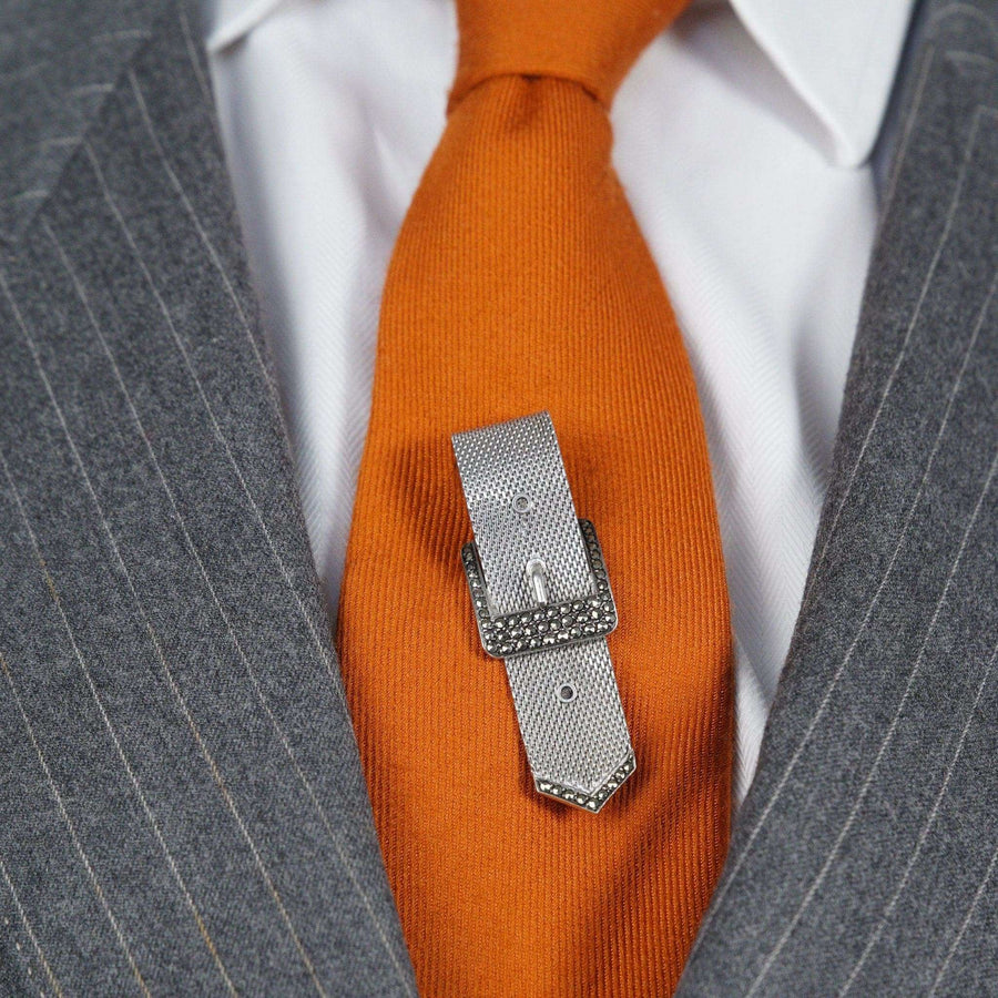 Mid Century silver and marcasite buckle brooch on an orange tie, showcasing its timeless and versatile design.