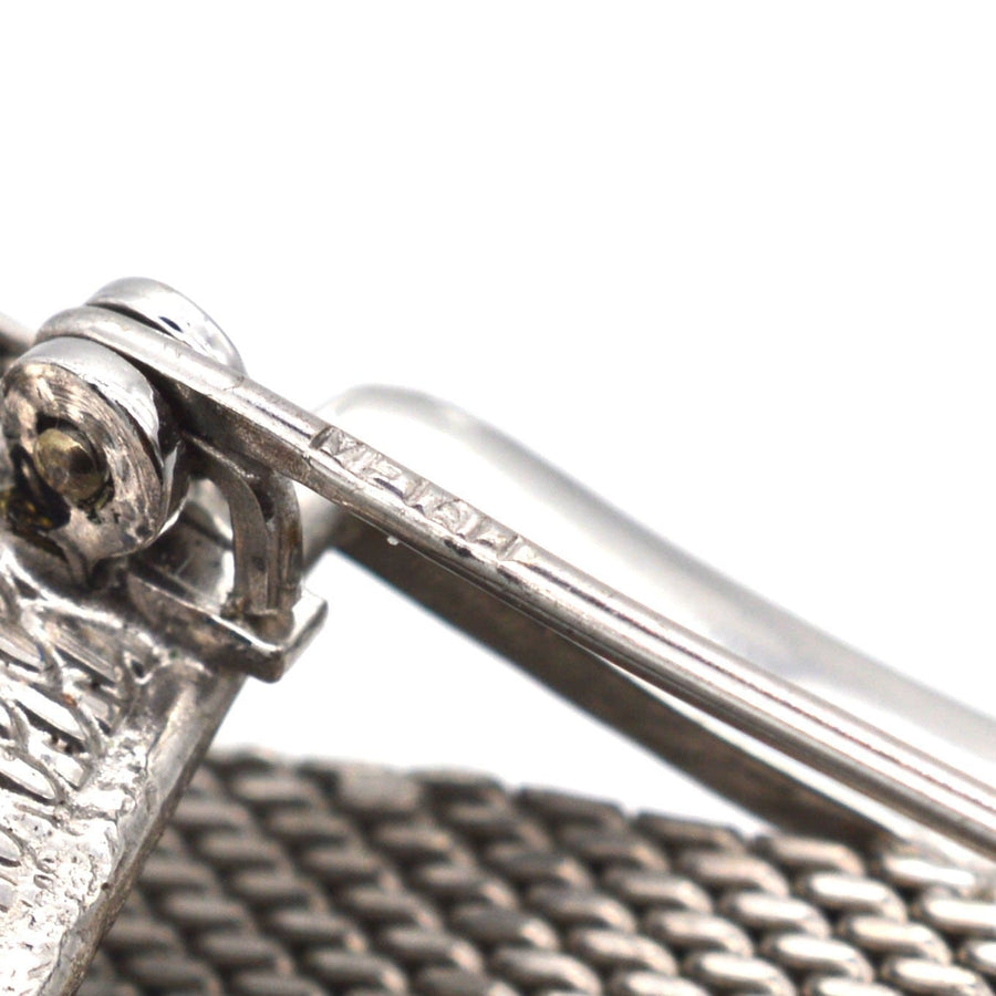 Close-up of a mid century silver buckle brooch showing intricate detail and marcasite embellishments.