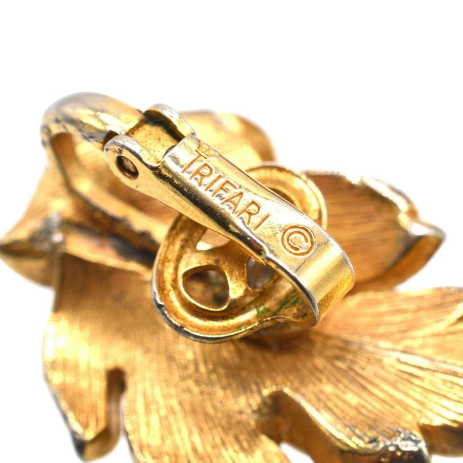 Close-up of Trifari gilt metal clasp from Mid Century leaf earrings, showcasing baroque style craftsmanship.
