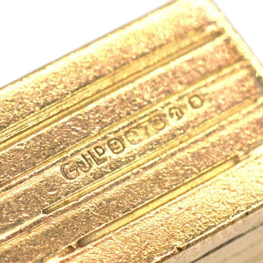 Close-up of gold and enamel charm showcasing detailed engraving by Georg Jensen Ltd.