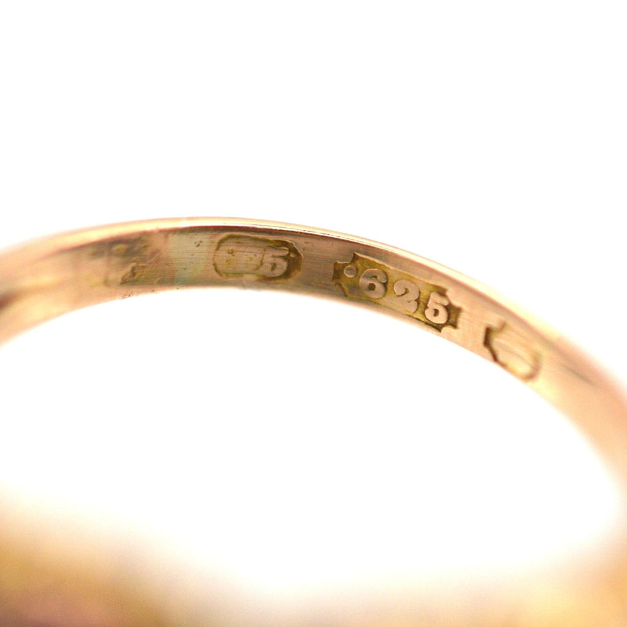 Close-up of the hallmark on a gold ring indicating purity and craftsmanship details.