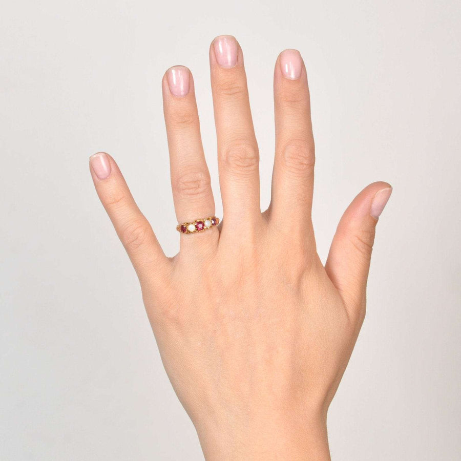 Regency 15ct gold ring featuring garnet and opal stones, elegantly worn on a hand.
