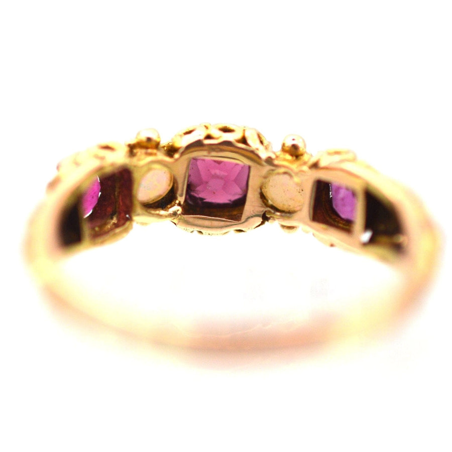 Close-up of a Regency gold ring featuring purple garnets, showcasing its intricate design and vibrant gemstones.