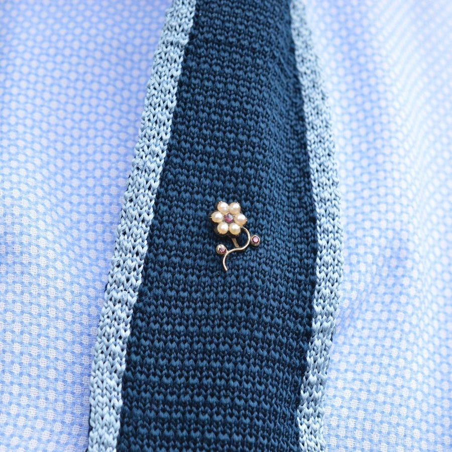 Regency 9ct gold split pearl and garnet flower tie pin on a silk tie, showcasing elegance and timeless design.