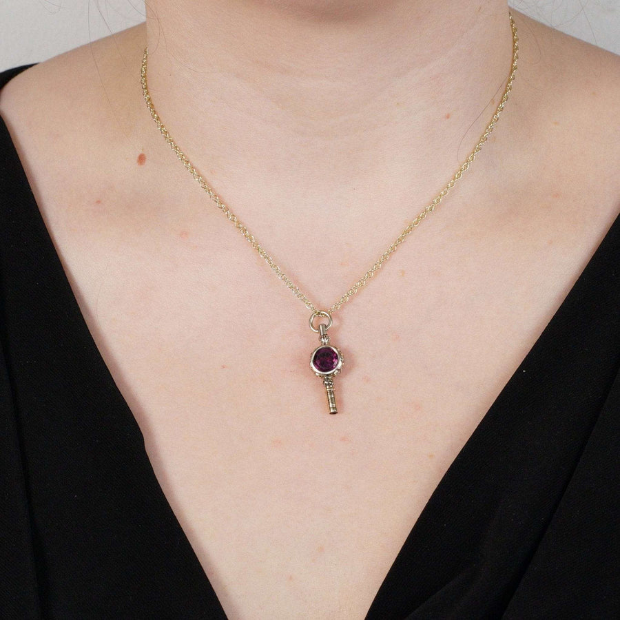Elegant gold cased watch key pendant featuring amethyst paste, styled in the Regency fashion on a model.