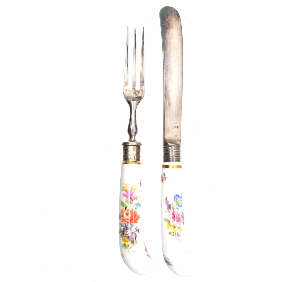 Set of antique silver cutlery with colorful porcelain handles, including a fork and knife.