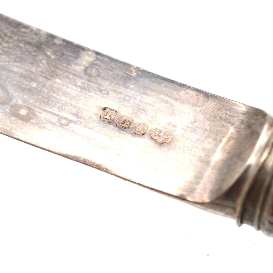 Close-up of hallmarks on a silver knife blade by T. Goode & Co, dated 1896, showcasing its antique craftsmanship.