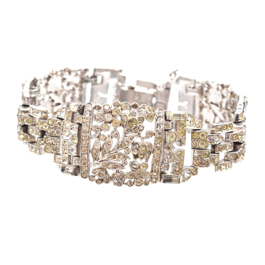 1940s Trifari silver-tone wide bracelet with white paste stones, featuring floral design accents and vintage elegance.