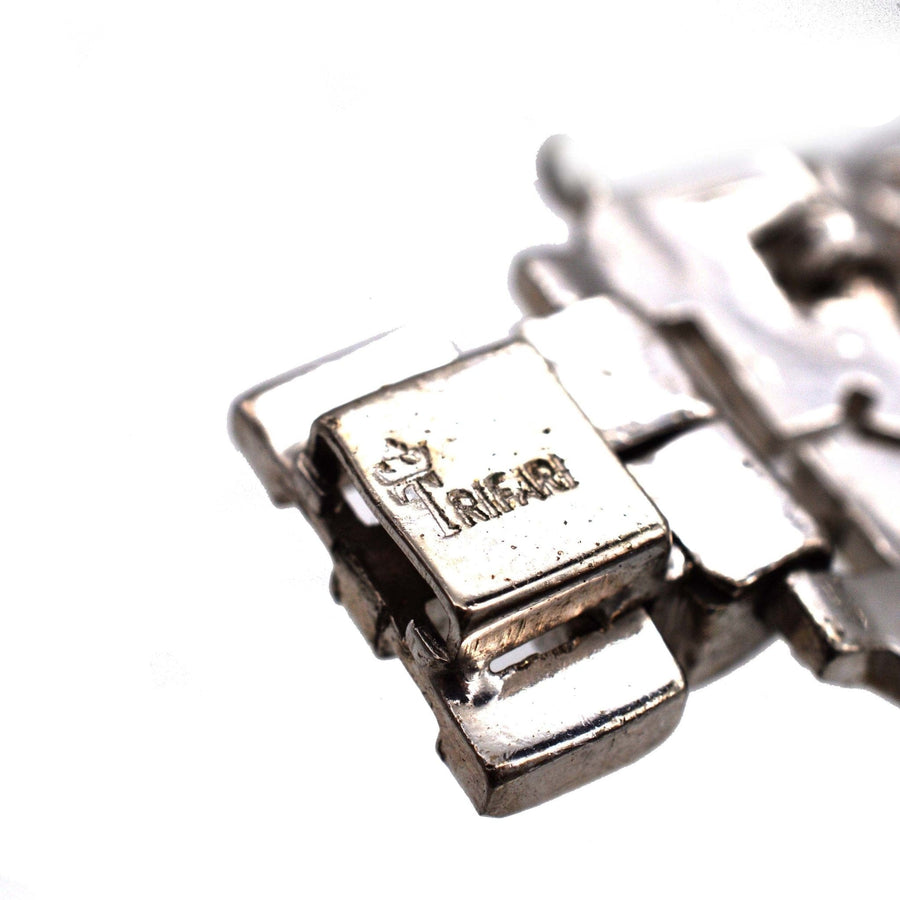 Close-up of Trifari 1940s silver-tone bracelet clasp, showcasing intricate design and brand signature.