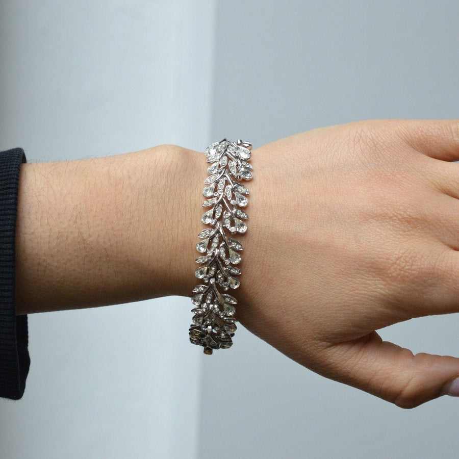 Trifari 1950s white diamond paste bracelet modeled as a floral wreath, showcasing elegant leaf design with sparkling stones.