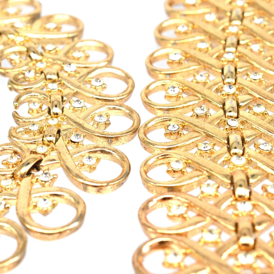 Close-up of Trifari gold-tone paste bracelet with interlinked swirls and sparkling diamond pastes.