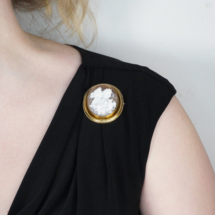 Victorian 15ct gold Day and Night shell cameo brooch worn on a black dress, featuring a delicate gold frame.