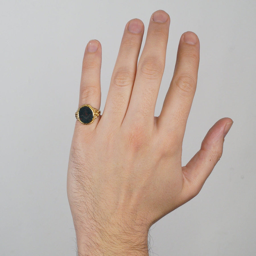 Victorian 15ct gold Masonic signet ring with bloodstone worn on a hand, highlighting intricate details and design.