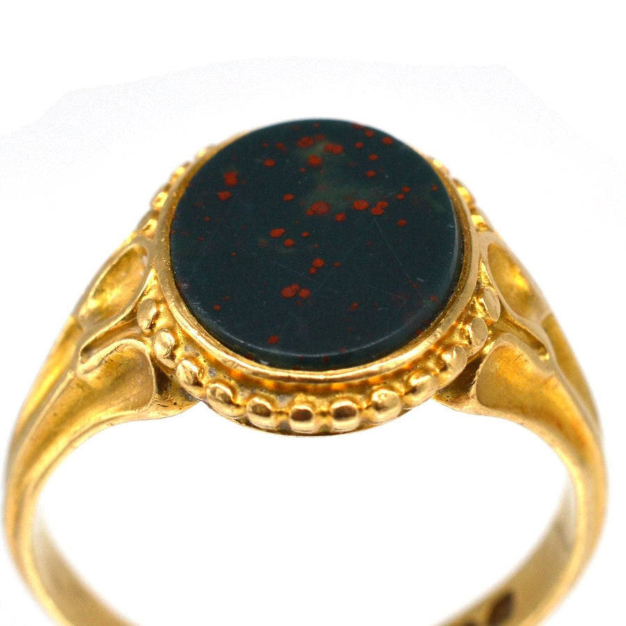 Victorian 18ct gold bloodstone signet ring showcasing the exquisite stone and decorated shoulders, dated 1858.