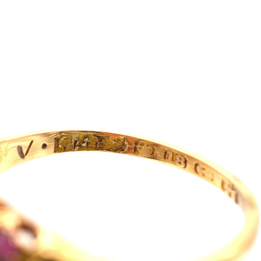 Close-up of the hallmarks on a Victorian 18ct gold ruby and diamond ring, showcasing its fine craftsmanship.