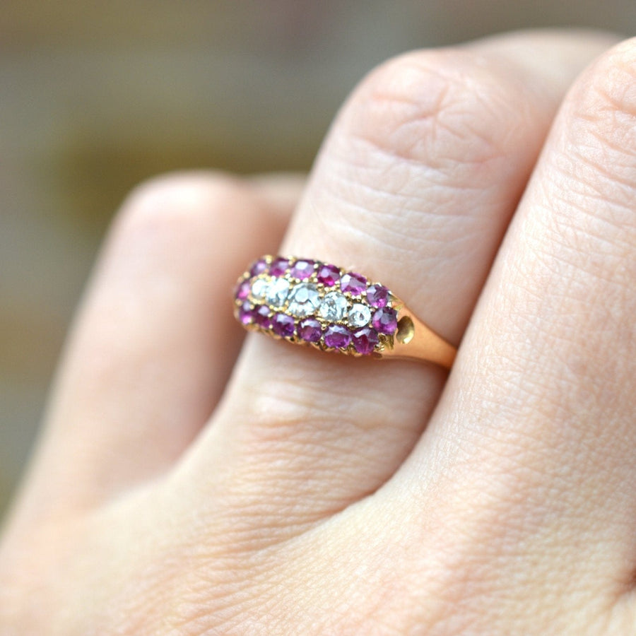 Victorian 18ct gold boat-shaped five stone diamond and ruby cluster ring worn on a finger.