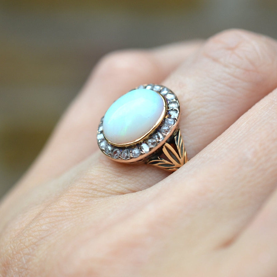 Victorian 18ct gold ring featuring a milky green opal surrounded by rose diamonds, elegant design from the 1860s.