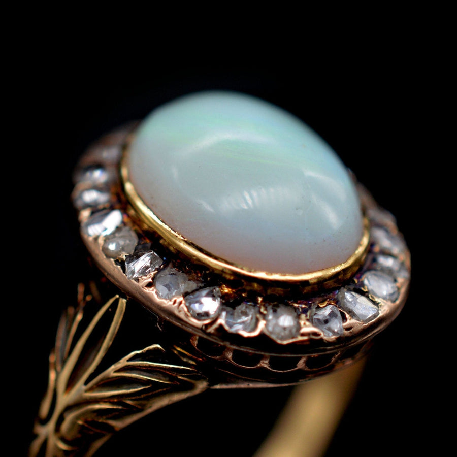 Victorian 18ct gold ring featuring a milky green opal surrounded by rose diamonds, dating to the 1860s.