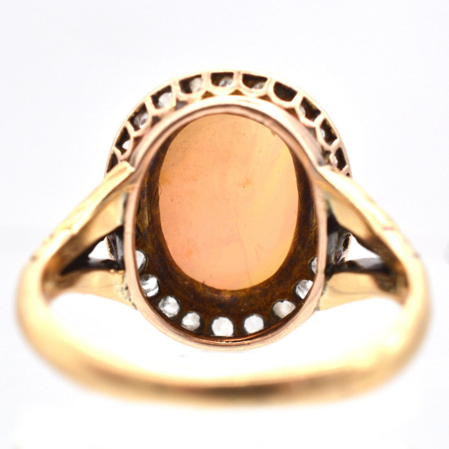 Vintage gold ring featuring a central oval garnet stone and intricate filigree band design.