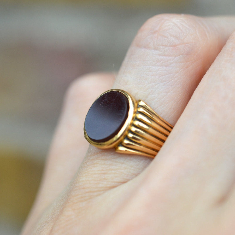 Victorian 18ct gold signet ring with carnelian stone, featuring incised grooves, worn on hand.