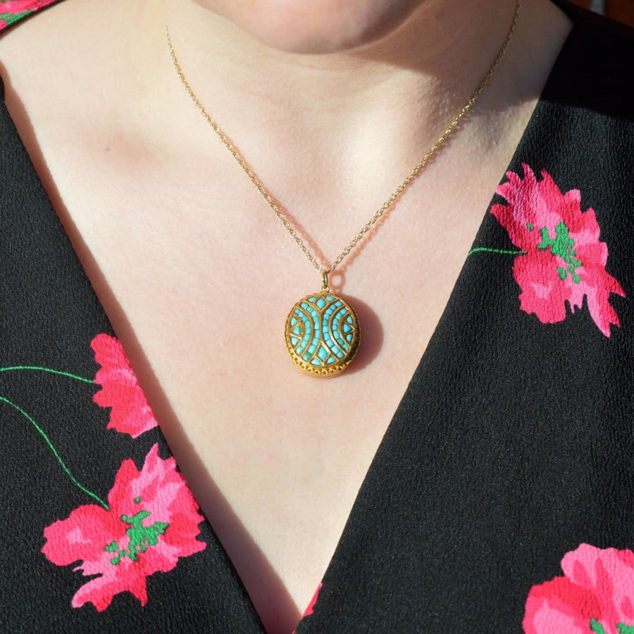 Victorian 18ct gold turquoise pavé locket displayed on a model in a floral dress.