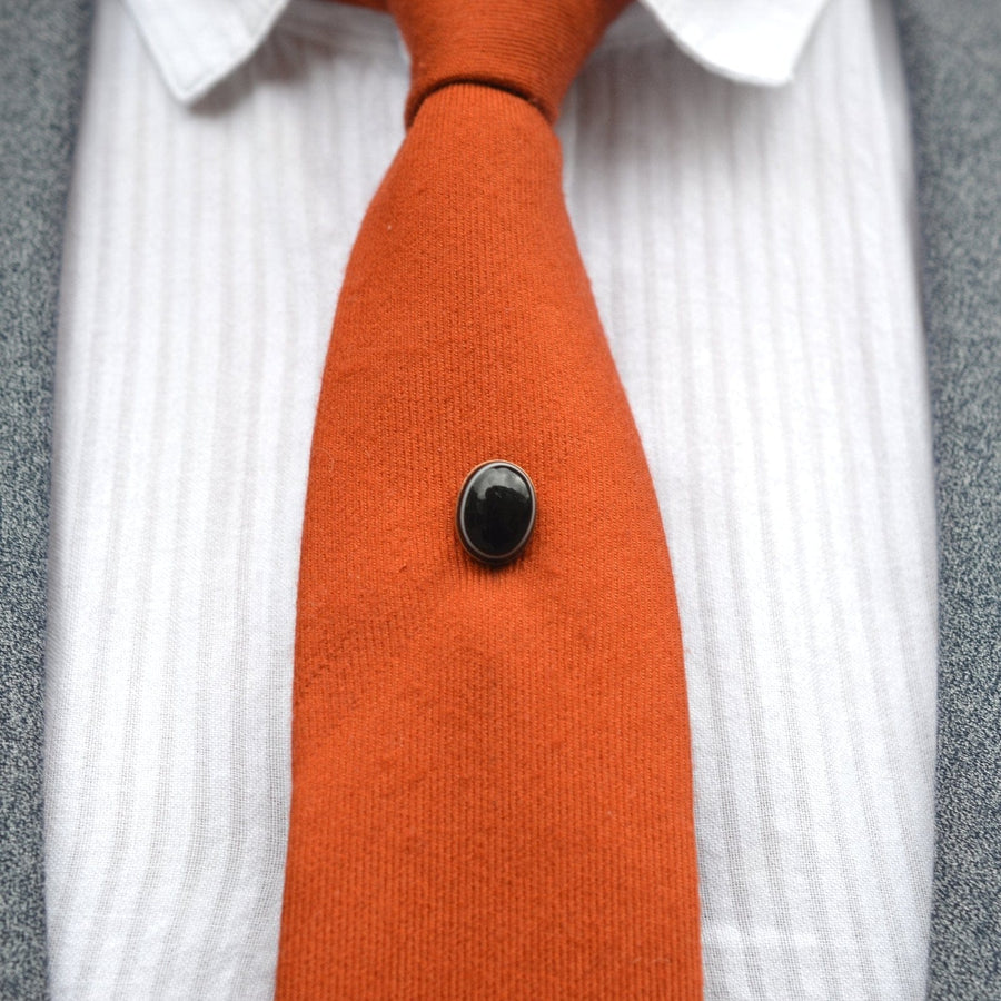 Victorian 9ct gold tie pin featuring black banded onyx on an orange tie, showcasing unique craftsmanship from the 19th century.