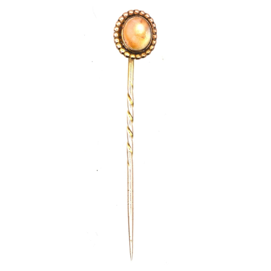 Victorian 9ct gold tie pin with brown cat's eye shell, dated 1880s-1890s, featuring a twisted design and protective operculum.