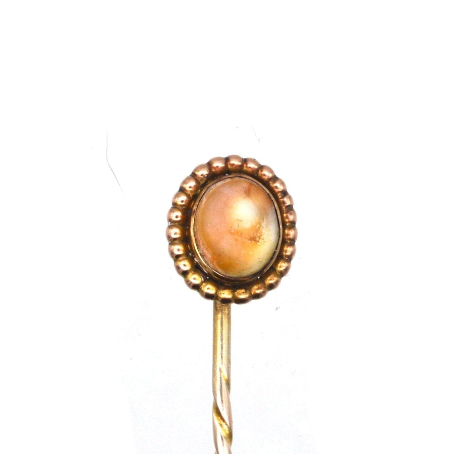 Victorian 9ct gold tie pin featuring a brown shell center, circa 1880s-1890s, with decorative beaded edge.