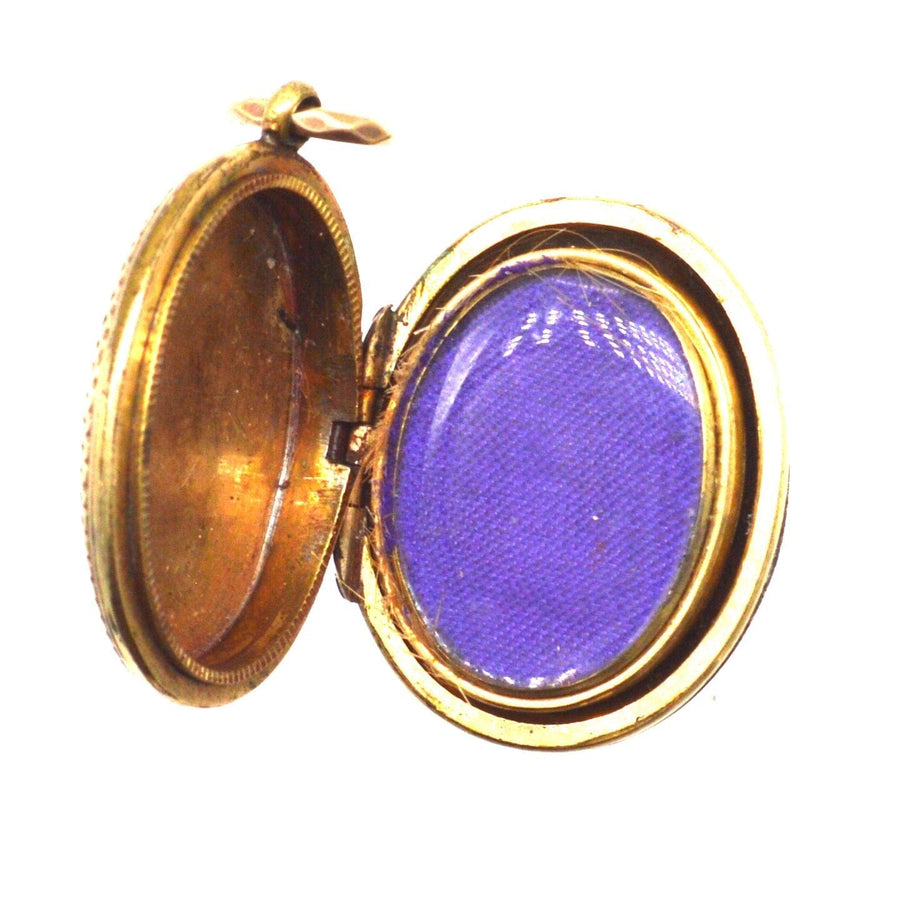 Open Victorian 9ct gold floral locket showcasing its inner compartment with purple fabric.