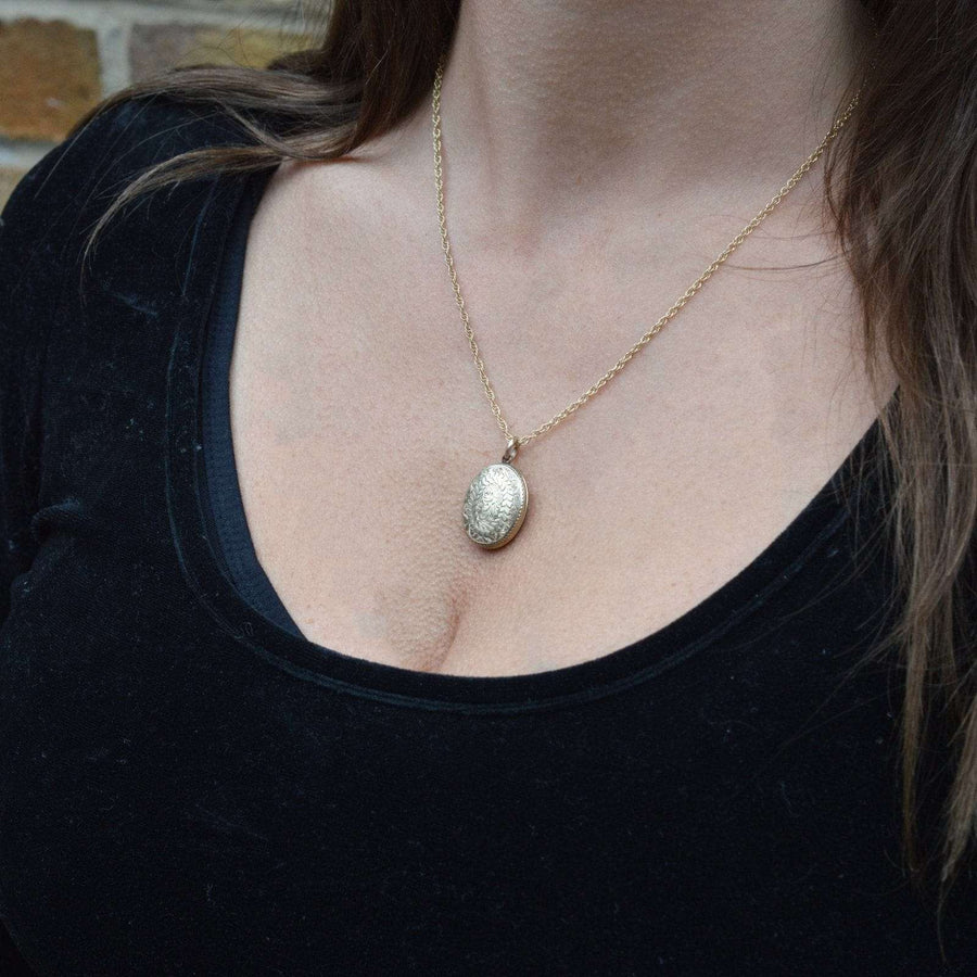 Victorian 9ct gold floral locket necklace worn on a woman, showcasing its elegant design and shine.