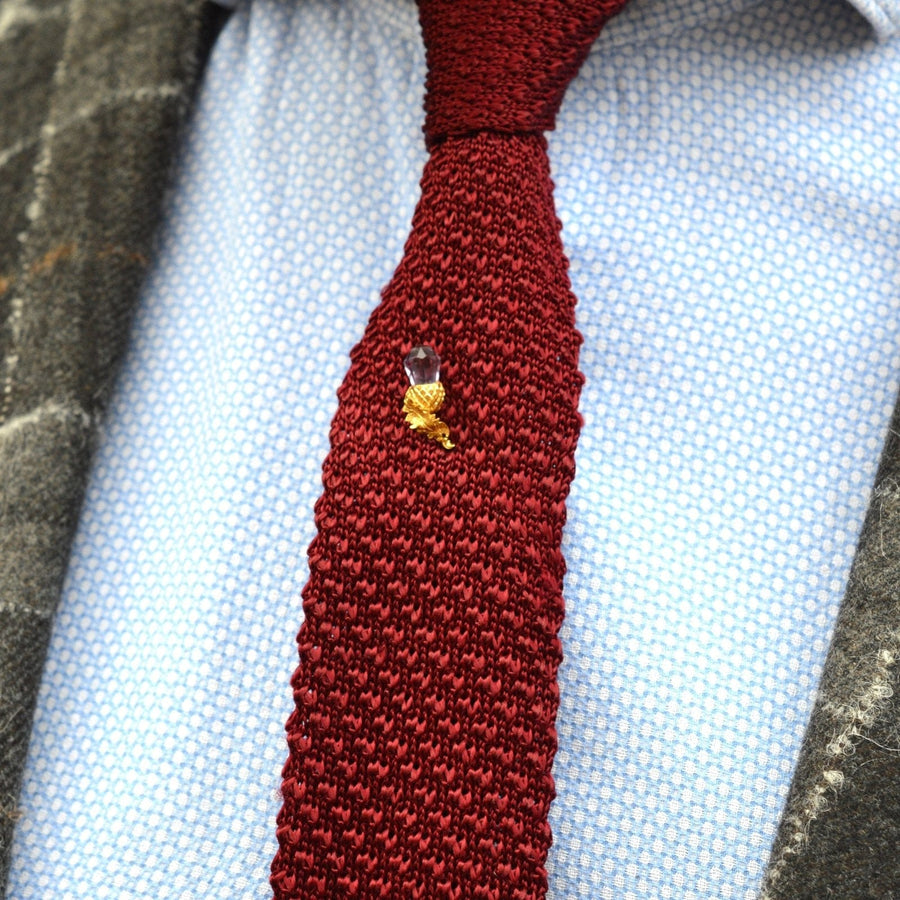 Victorian 18ct gold tie pin with amethyst thistle on a burgundy silk tie, perfect for grooms or antique jewelry lovers.