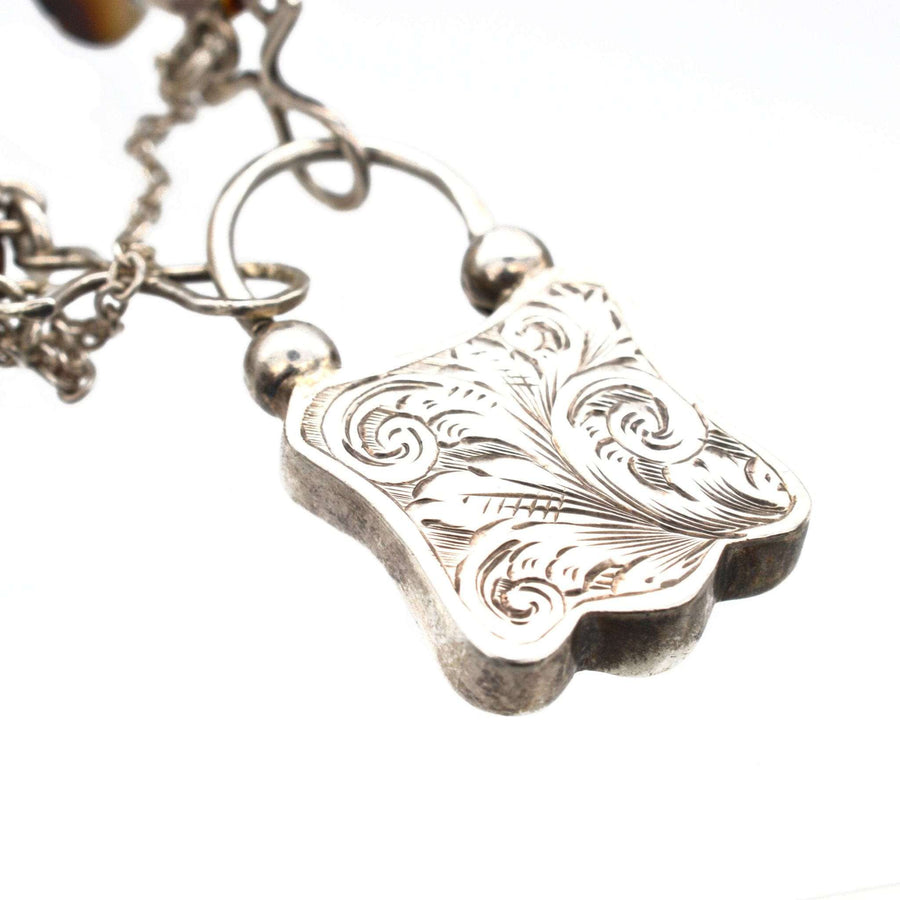 Close-up of Victorian Scottish silver padlock clasp featuring intricate swirl details from a 1860 agate bracelet.