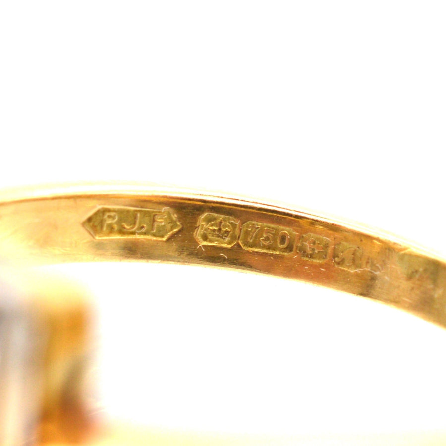 Hallmark details of a vintage 18ct gold and platinum diamond square ring, showing date and purity markings.